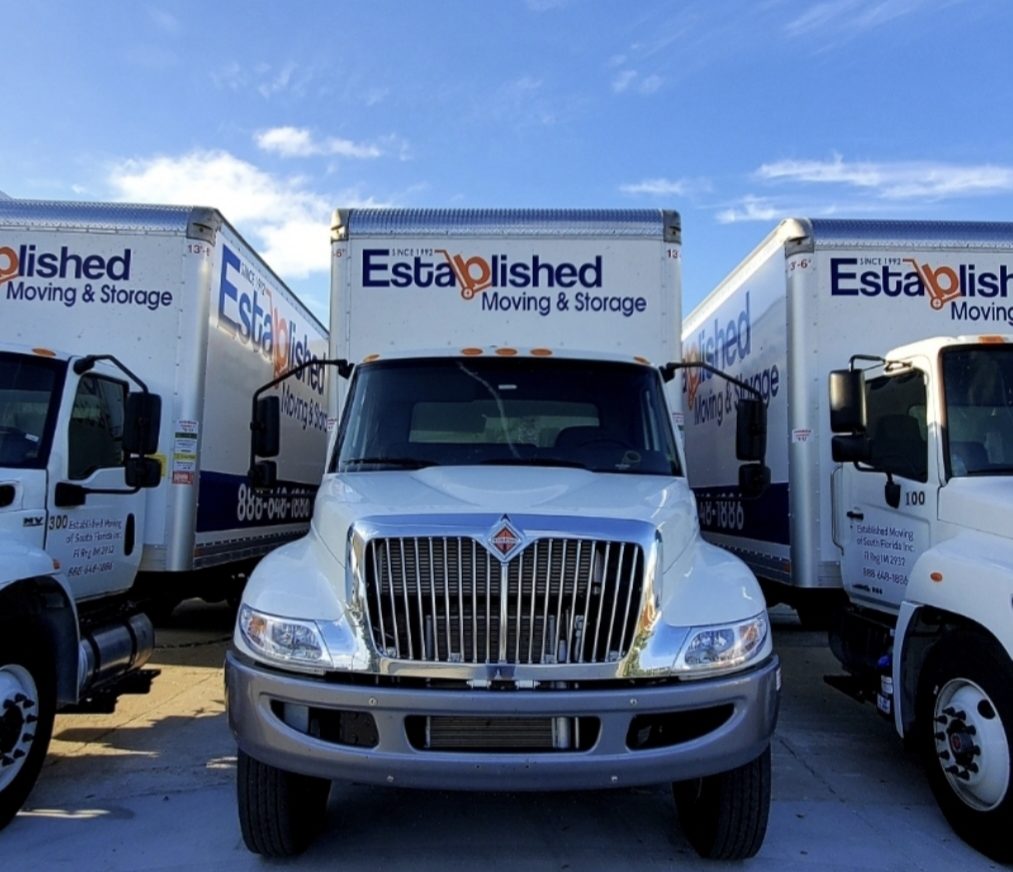 established moving & storage trucks sit ready to drive