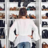 A woman staring at a closet full of shoes